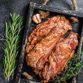 Raw marinated brisket steaks