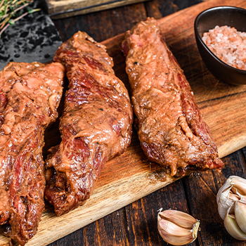 Marinated raw brisket meat on a chopping board