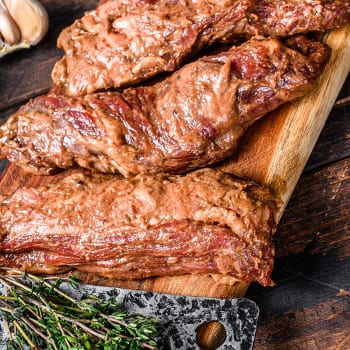Marinated raw brisket meat on a chopping board