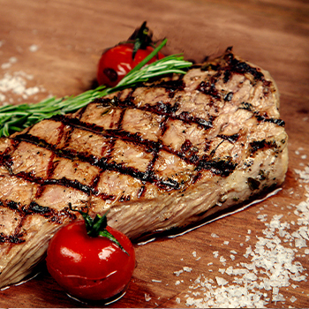 A piece of steak on a wooden board