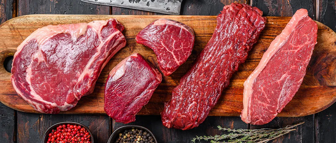 Top view of different meats on a wooden board