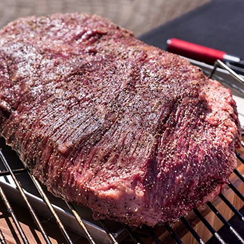 A large brisket on top of a grill rack