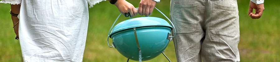 Couple holding a colored portable grill