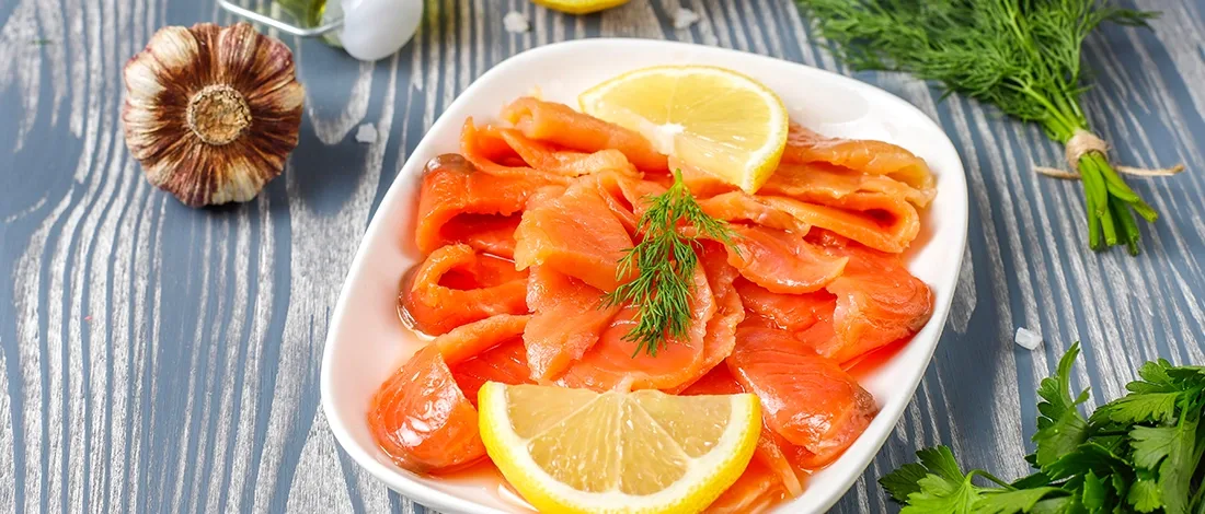 Smoked salmon with lemon slices on plate