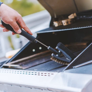 Close up shot of a person cleaning grill grates