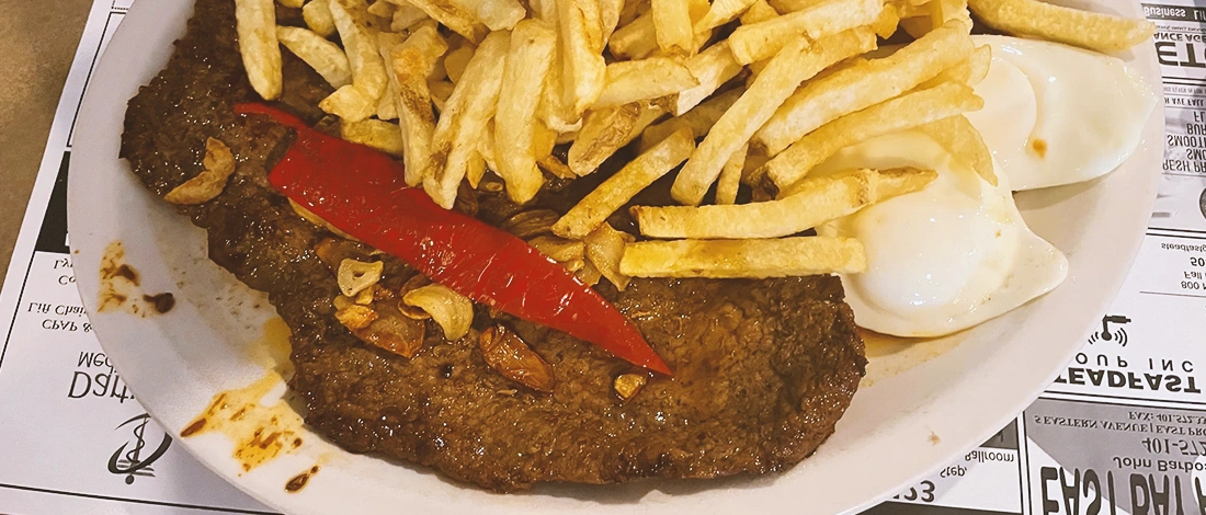 Close up shot of caravela portuguese steak on a plate with fries and eggs