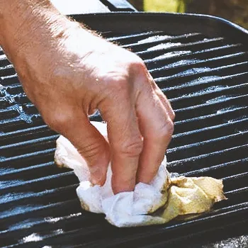 A person cleaning a grill