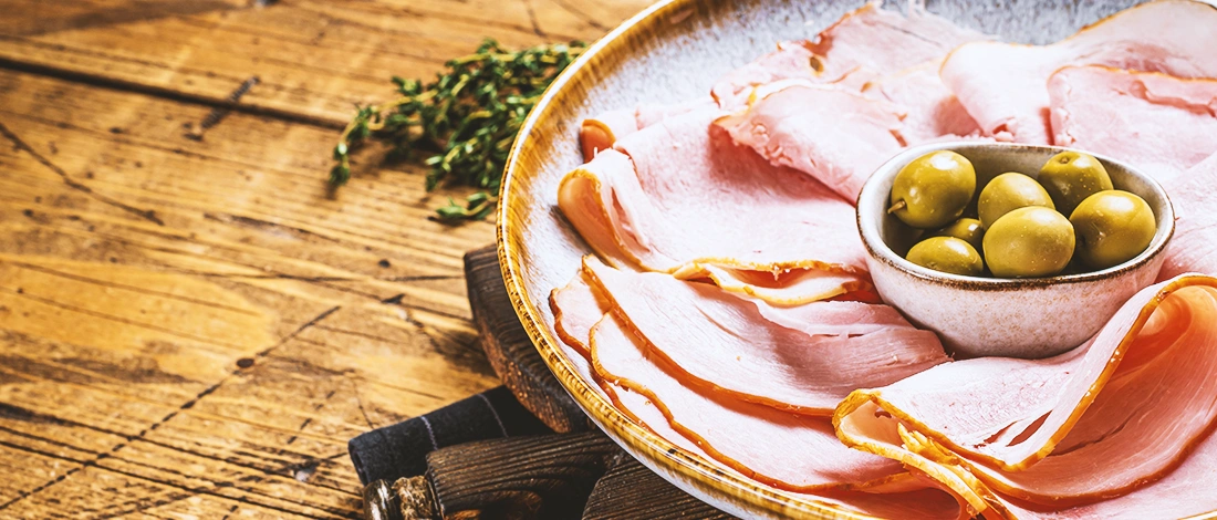 A stack of deli on a wooden bowl