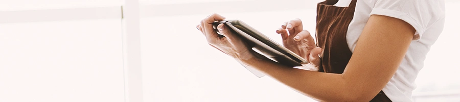 A chef using a tablet in a kitchen