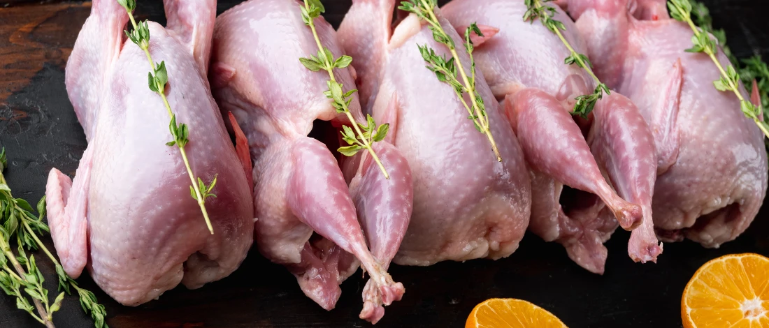 Five quail meats on a chopping board