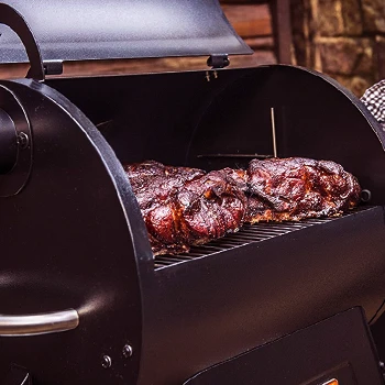 A smoker that is open and has meats inside