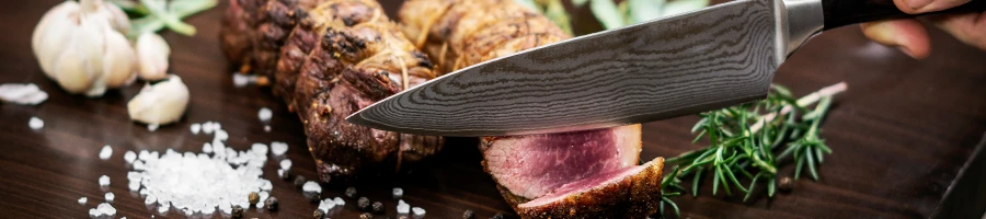 An image of person slicing a steak