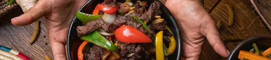 A person holding a fajita dish in a bowl
