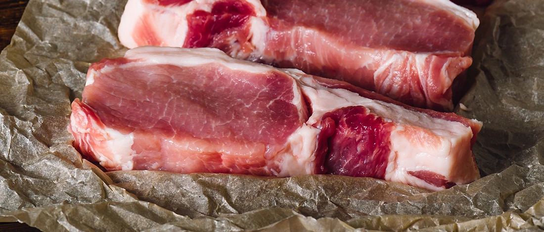 A close up image of pork meat on top of a paper packaging