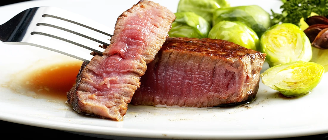 Perfectly cooked filet mignon on a white plate