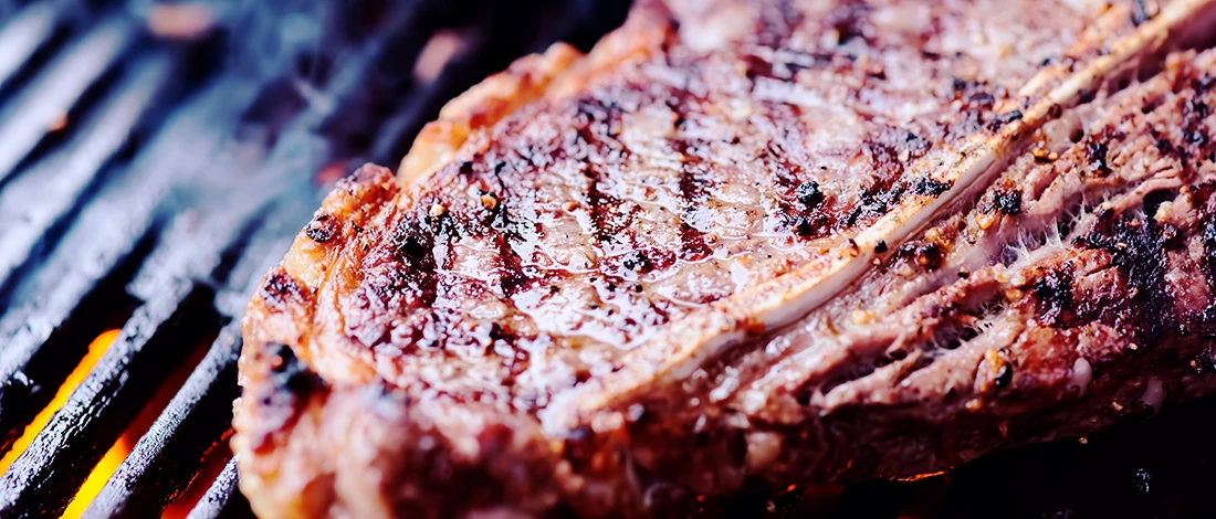 A close up shot of a steak being grilled