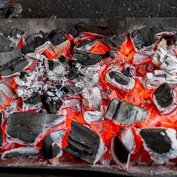 Charcoal in flames inside a smoker