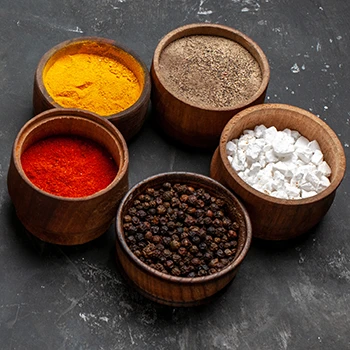 Different rubs and seasonings on a wooden bowl