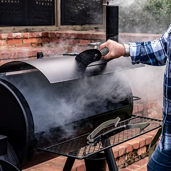A man opening the lid of a smoker
