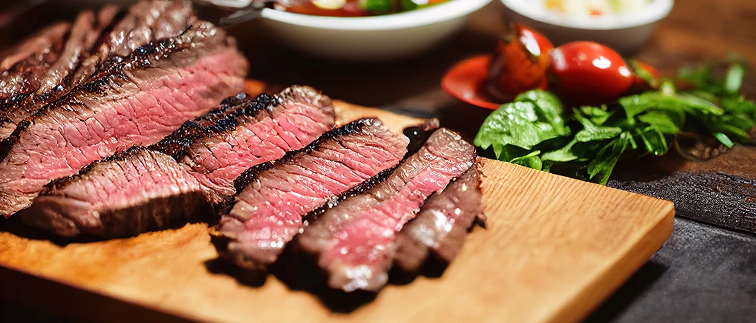 A delicious steak sliced up on a wooden board