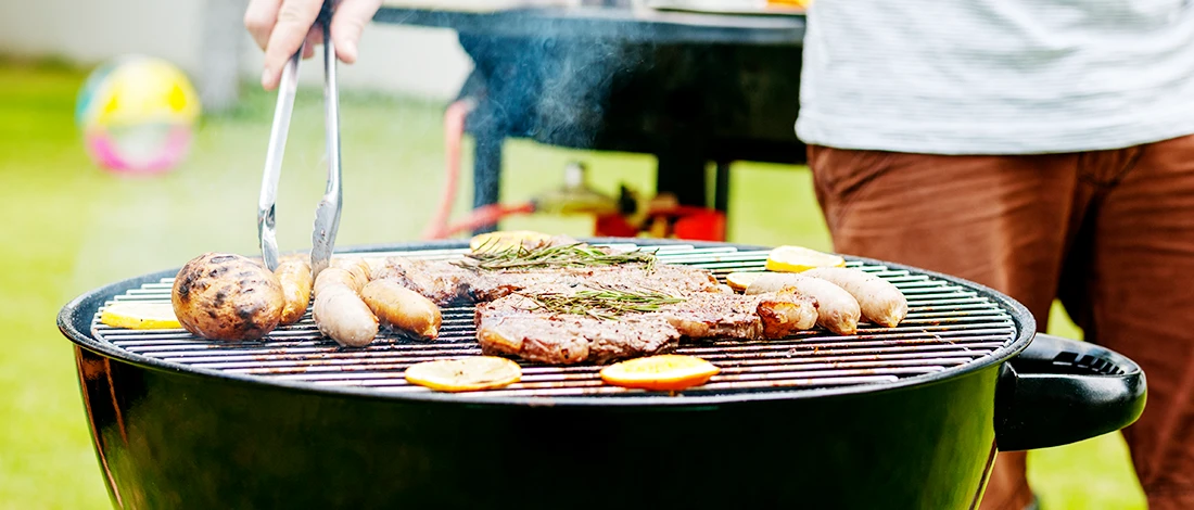 A close up shot of a man having a barbeque outdoors