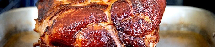 A close-up shot of a frozen ham being cooked in an oven
