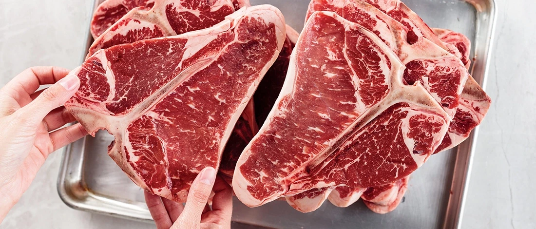 A top view of a person about to defrost frozen steaks