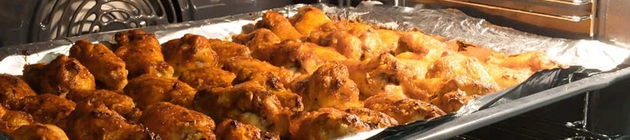 Chicken wings being reheated in an oven