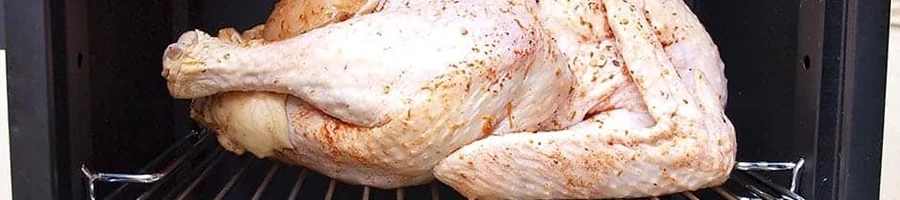 A partially frozen turkey placed inside the smoker