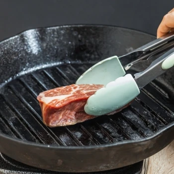A person frying filet mignon