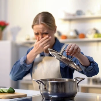 A woman cooking spoiled food in the kitchen