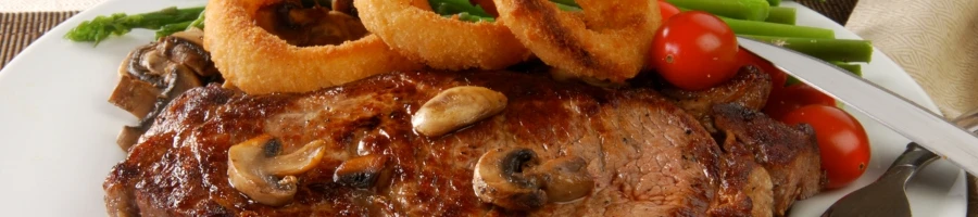 A delicious steak with onions and mushrooms on top