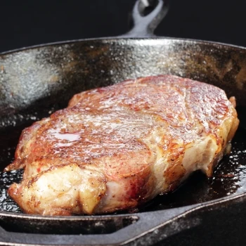 The steak is cooking on a pan