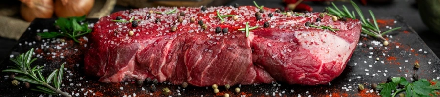 A side view of seasoned raw steak.