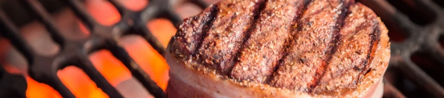 A bacon wrapped steak on a grill