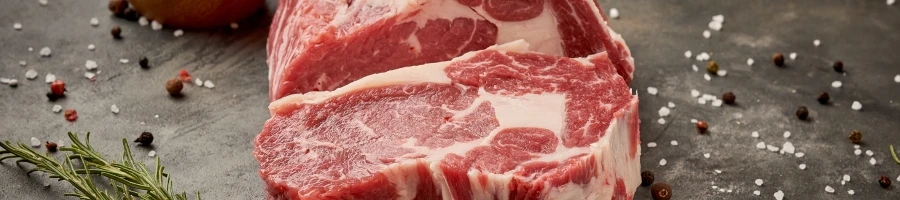 A sliced fresh raw meat with scattered salt and pepper