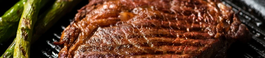 A steak cooking on a skillet