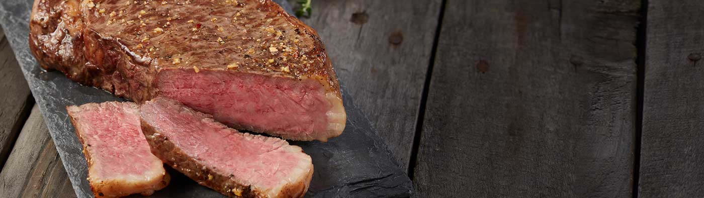 New York strip steak on cutting board