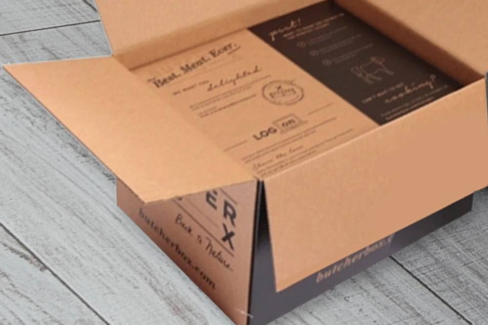 A ButcherBox food delivery package on the floor with an opened carton