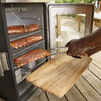 placing meat inside an electric smoker