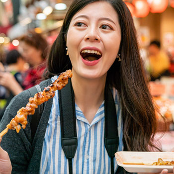 asian woman eating yakitori