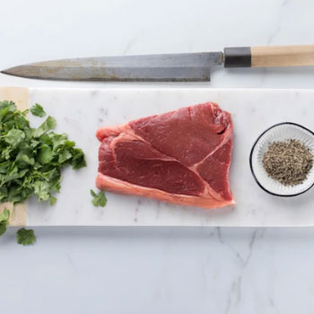 raw sirloin steak on a knifeboard
