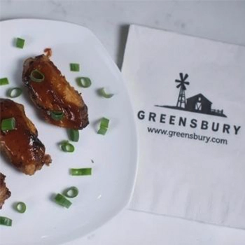 Greensbury meat on a plate beside the logo of Greensbury