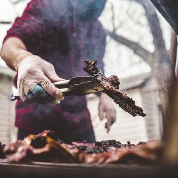 Man grilling meat on a pellet grill