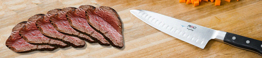 Stacked tri tip cut steak and a knife on a chopping board