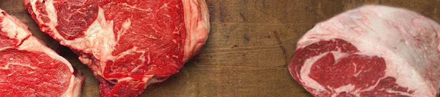 Closeup top view of three steaks on a wooden surface