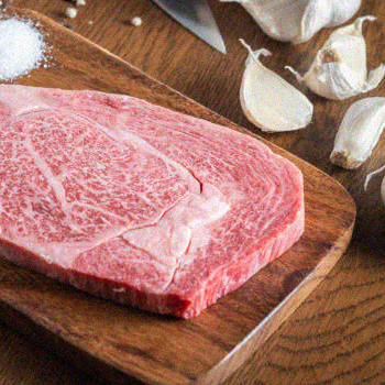 Wagyu beef on a chopping board with garlic