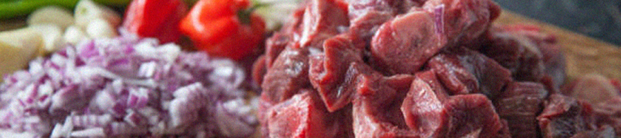 A goat meat on chopping board preparing to cook