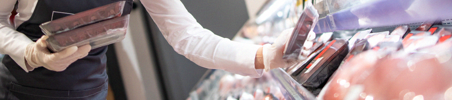 Supermarket worker organizing meat section