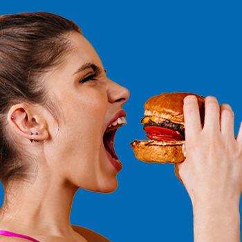 Woman taking a big bite on a burger